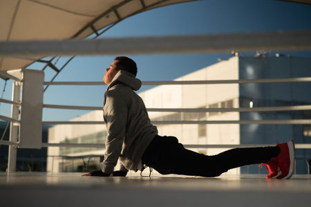 Caucasian male boxer warming up before a fight in the ring outdoors.の写真素材