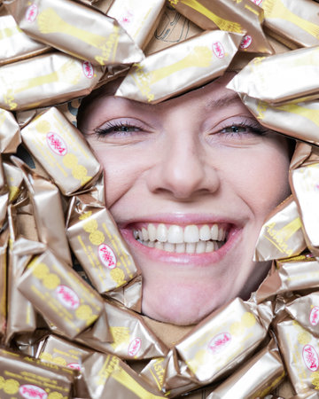 The face of a caucasian woman surrounded by Rakhat chocolates.のeditorial素材