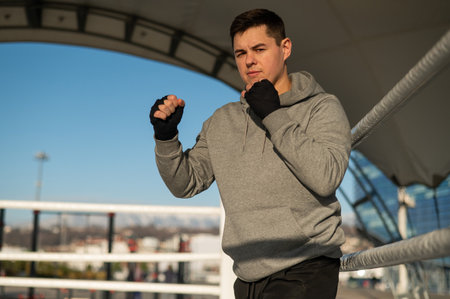 A man in a hoody trains in boxing at the stadium.の写真素材