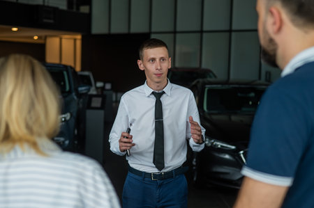 Happy caucasian couple choosing a new car in a car dealership.の写真素材
