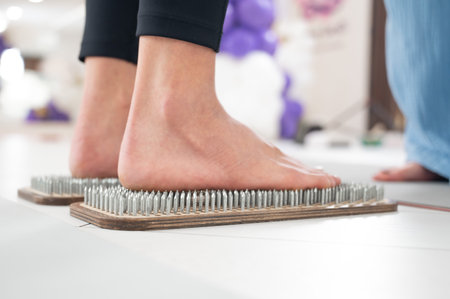 Caucasian woman stands on sadhu boards with therapist support.の写真素材