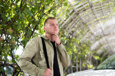 Young caucasian man with hearing device walking outdoors.の写真素材