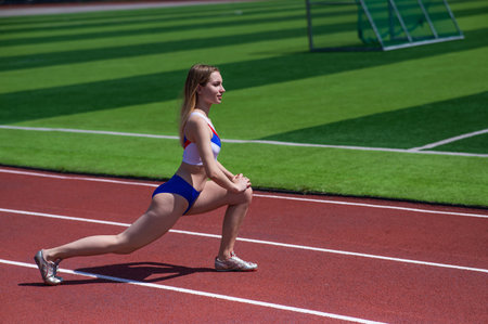 Young caucasian woman is engaged in jogging at the stadium outdoors.の写真素材