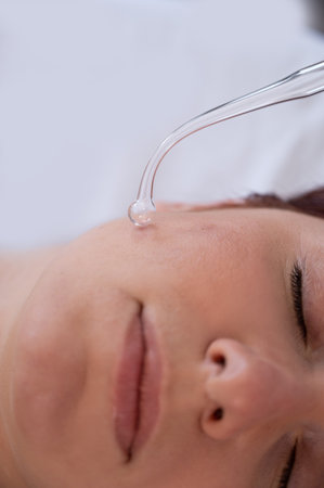The doctor uses the darsonval apparatus against acne on the face of a female patient.