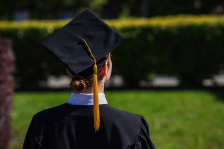 A woman throws her graduation cap against the blue sky.の写真素材