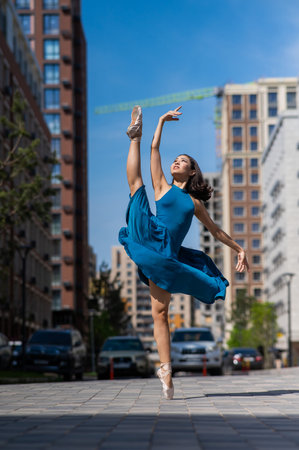 Beautiful Asian ballerina dancing outdoors. Urban landscape.の写真素材