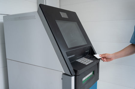 Close-up of womans hands using ATM with contactless nfs access.の写真素材