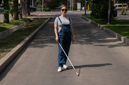 Blind pregnant woman walking down the street with a cane.