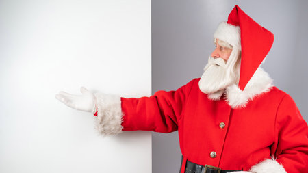 Santa claus points to an empty space. Christmas advertisement.の写真素材