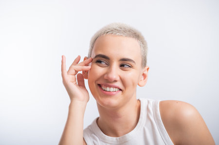 Pretty young woman with a short blond haircut on a white background.の写真素材