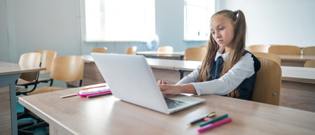 Caucasian girl studying on a laptop in a classroom.の写真素材