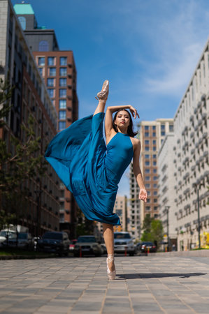 Beautiful Asian ballerina dancing outdoors. Urban landscape.の写真素材