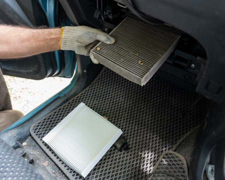 A mechanic changes the cabin air filter of a carの写真素材