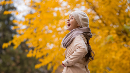 Happy caucasian girl in a beige coat and beret walks in the park in autumn