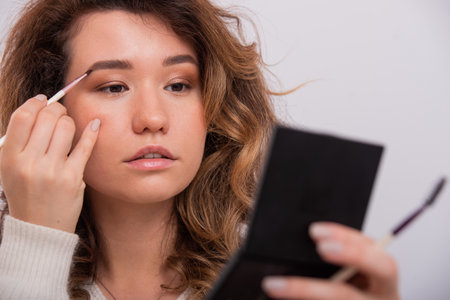Portrait of a Caucasian young woman doing makeup