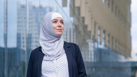 Portrait of smiling business woman in hijab and suit outdoorsの写真素材