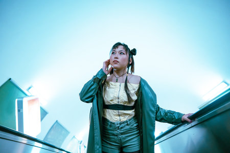 Portrait of an Asian young woman on the escalator in the subwayの写真素材