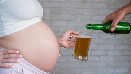 Man pouring beer for pregnant womanの写真素材