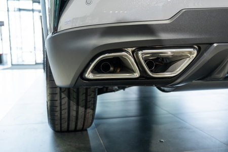 Double exhaust pipe in a new car in a car showroomの写真素材
