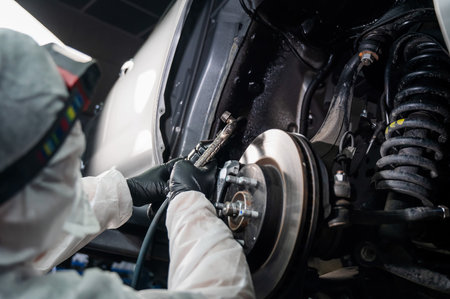 An auto mechanic applies anti-corrosion mastic to the underbody of a carの写真素材