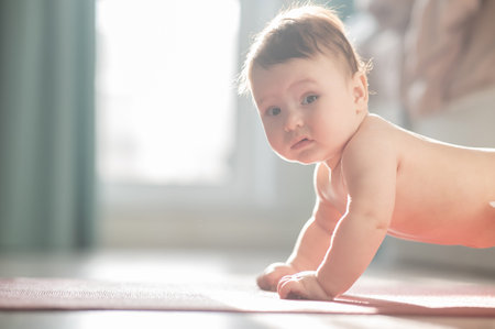 Cute little boy standing on all fours on the floor