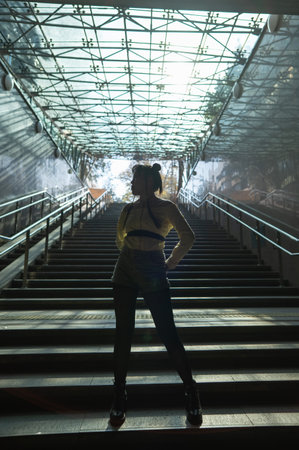 Portrait of a young Asian woman posing in the subway near the stairs