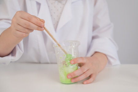 Faceless girl doing chemical experiments on a white background. Making slimeの写真素材