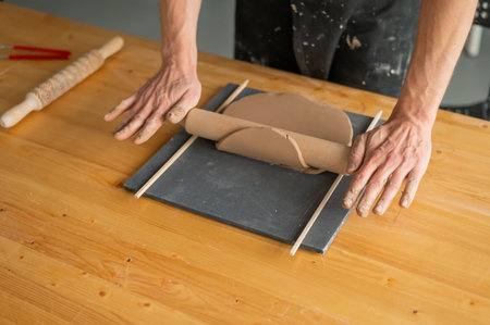 Close-up of potters hands rolling out clayの写真素材