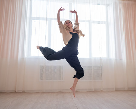 Caucasian woman dances contemporary in ballet class. Dancer in a jumpの写真素材