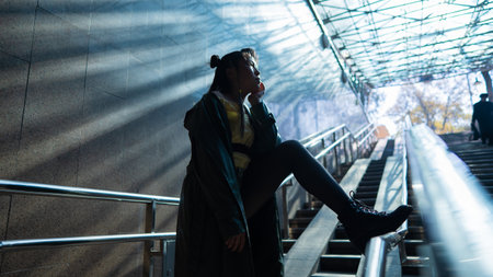 Portrait of a young Asian woman posing in the subway near the stairsの写真素材