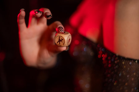 Seductive woman dressed in erotic fishnet holding dice with sex positionsの写真素材