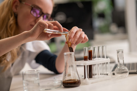 Caucasian woman in a medical gown doing laboratory experimentsの写真素材