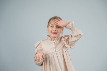 Little Caucasian girl having fun and making faces on a white backgroundの写真素材