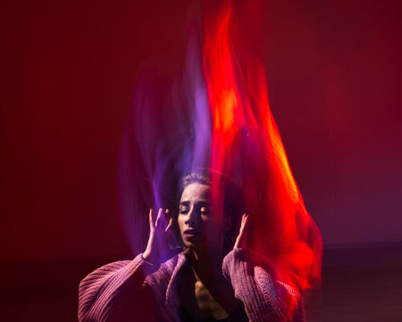 Young woman dancing modern dances in red blue neon light