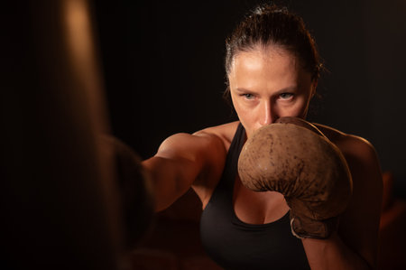 Caucasian woman boxing in retro gymの写真素材