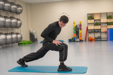 Caucasian man doing warm-up before exercise at a climbing wall