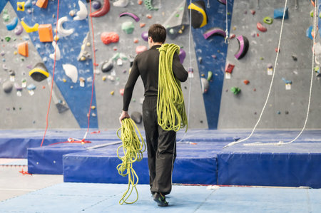 Caucasian man holding a safety rope during a lesson at a climbing wall