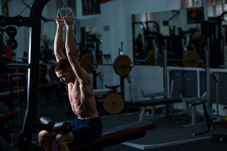 A man does a chest pulldown in the gymの写真素材