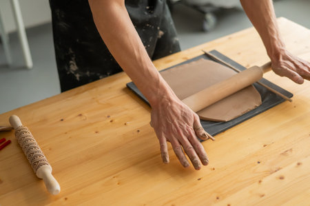 Close-up of potters hands rolling out clayの写真素材
