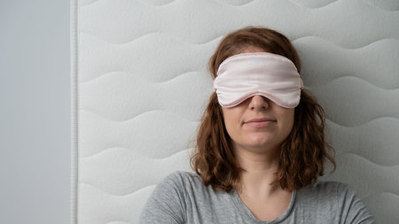 Top view of a happy woman sleeping in a sleep maskの写真素材