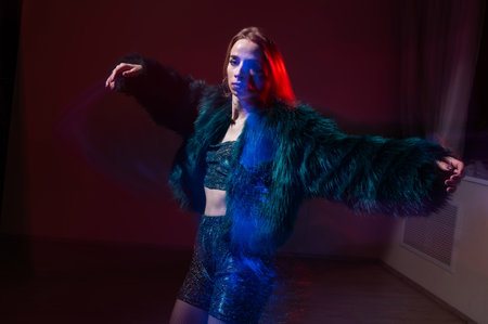 A young woman dances contemporary dances in blue and red light. Long exposure photoの写真素材