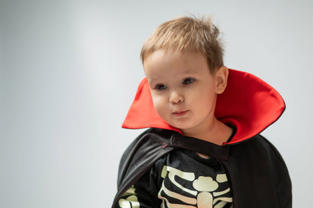 Portrait of a little Caucasian boy in a Dracula costume on a white background