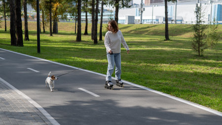 Caucasian woman roller skating with her jack russell terrier dog in park