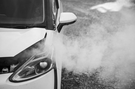 Smoke is coming from under the hood of the carの写真素材