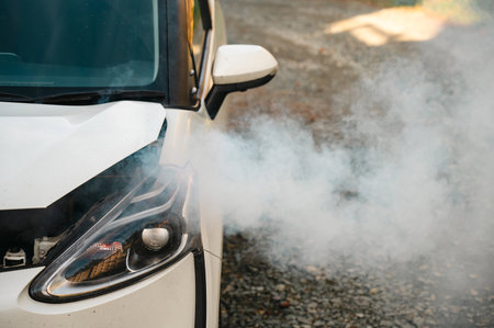 Smoke is coming from under the hood of the carの写真素材