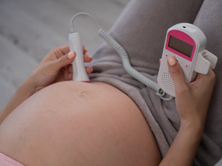 Close-up of a pregnant womans belly using a home doppler. Normal baby heartbeatの写真素材