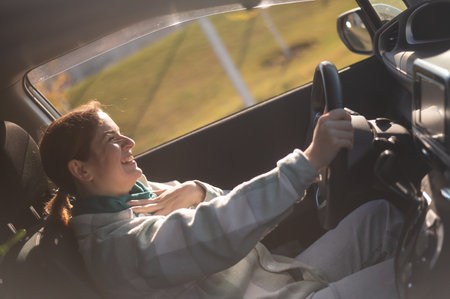 Happy Caucasian woman sitting behind the wheel and smilingの写真素材