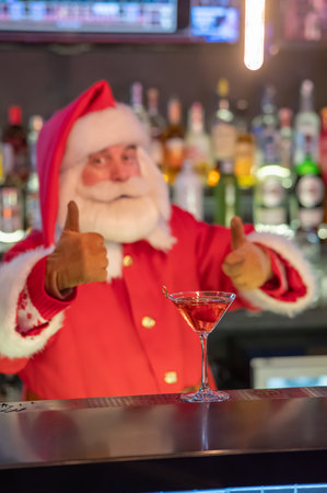 Santa Claus works at the bar making cocktails in a shakerの写真素材