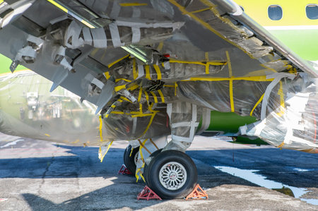 Airplane undergoing repairs in the open airの写真素材