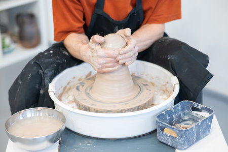 Close-up of a potters hands working on a pottery wheelの写真素材